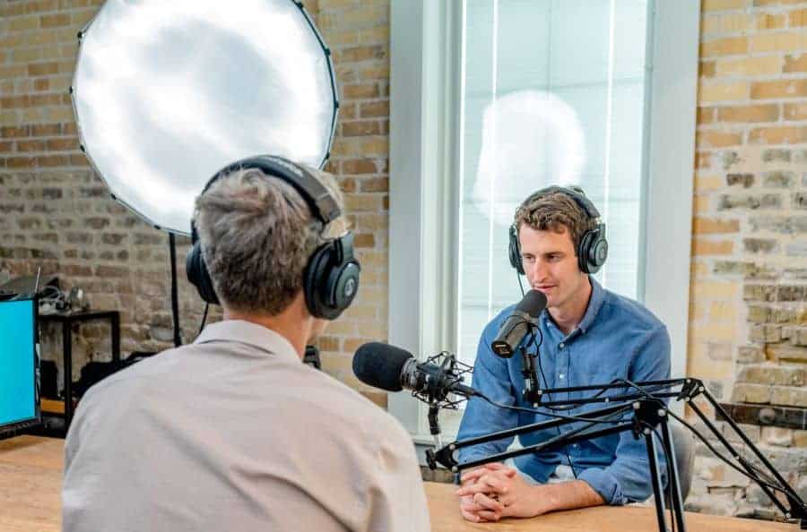 Two people recording a podcast with two microphones