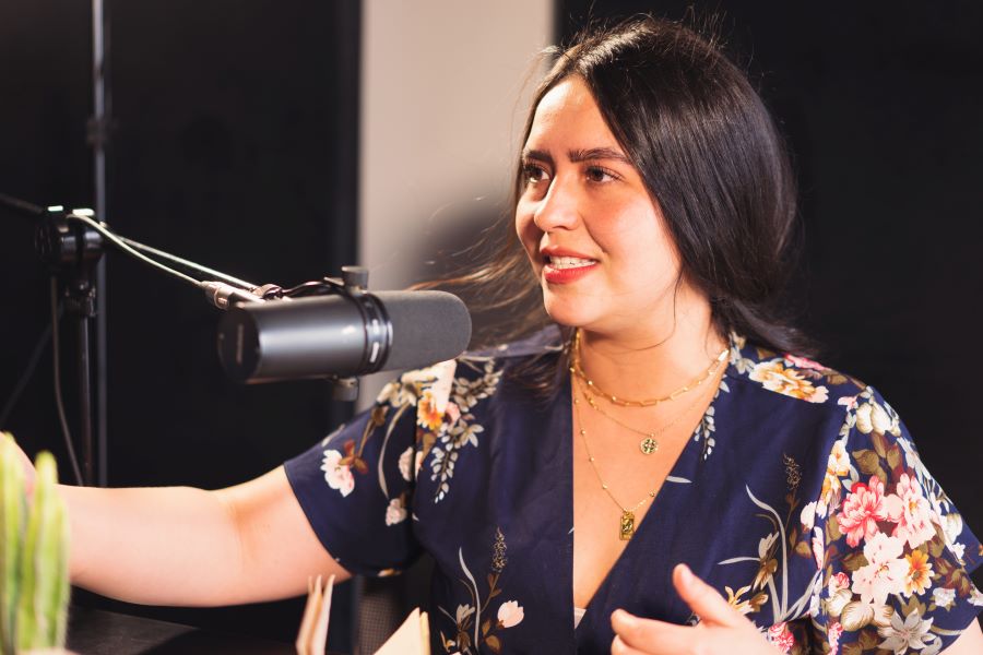 a woman talking in front of a mic