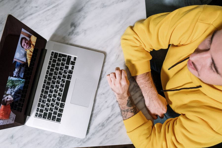 man in a yellow hoodie having a zoom call