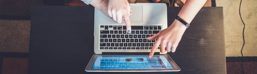 three person pointing to a laptop