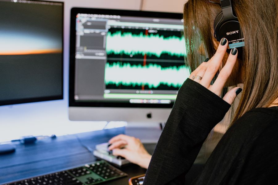 woman in black long sleeves editing a podcast