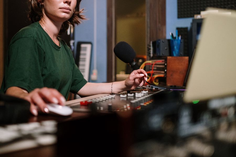 A Person in Green Crew Neck T shirt Holding Computer Mouse Infront of Audio