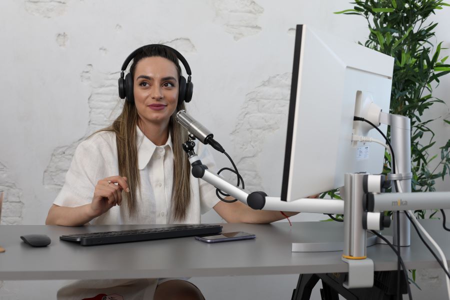 lady in white using headphones and XLR mic for recording