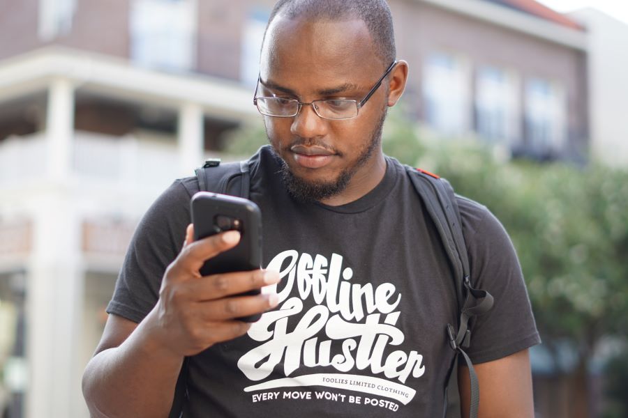 man in black shirt using android phone