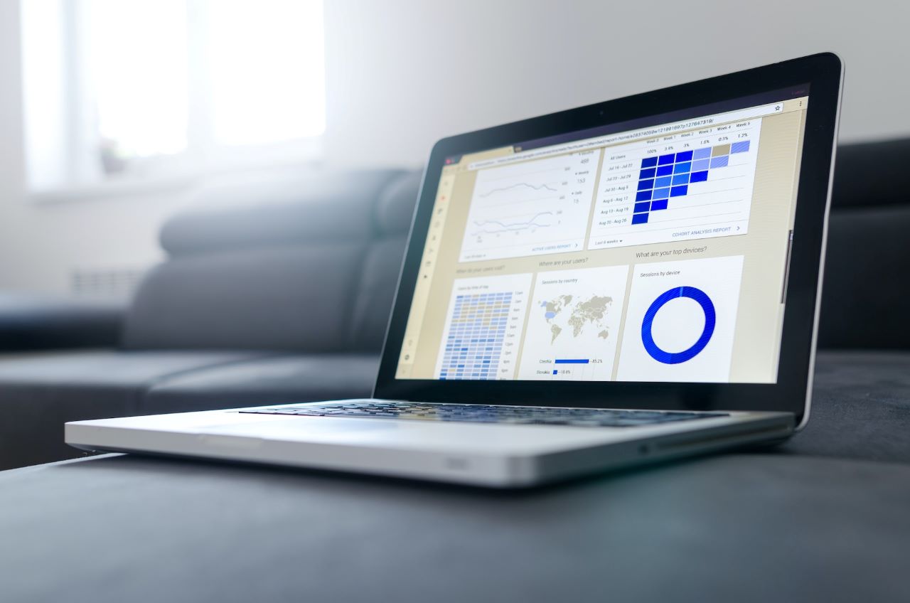 Laptop displays a dashboard tracking podcast analytics.